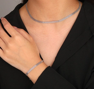 Macro shot of S925 sterling silver woven bracelet texture on model's wrist with black background