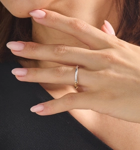Minimalist 925 silver ring on index finger featuring a small gold hanging charm detail