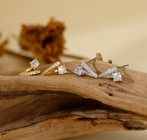 Détail de boucles d'oreilles en argent S925 en V avec micro-diamants sur bois