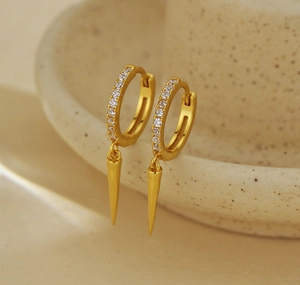 Detailed view of gold cone drop earrings with shimmering micro-pave zirconia crystals