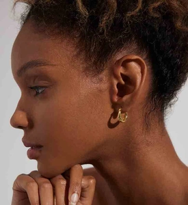 Close-up of elegant gold double-hoop earrings on model showing minimalist U-shape design