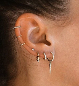 Close-up of stacked S925 sterling silver earrings with gold plating and spikes