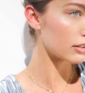 Detail shot of a gold-plated spike hoop earring with micro-pave diamonds on a model