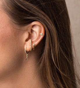 Detailed view of women wearing gold S925 sterling silver spike and star earrings set