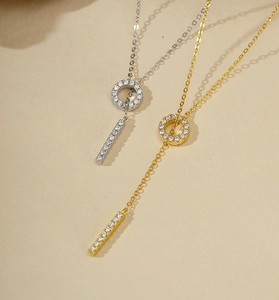Detailed view of silver and gold Y-shaped necklaces with pavé-set shimmering zircon stones