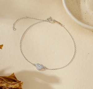 Macro shot of S925 sterling silver heart bracelet with pavé stones and lobster clasp