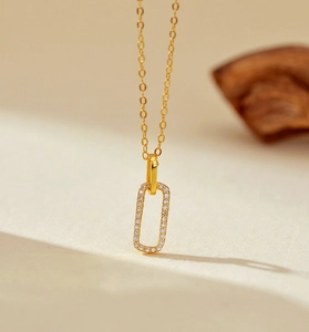 Macro detail of gold geometric rectangle pendant with micro-pave white zircon stones
