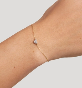 Close-up of gold S925 sterling silver bracelet featuring a micro-pave heart charm