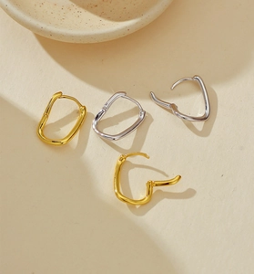 Macro view of gold and silver irregular geometric sterling silver hoop earrings