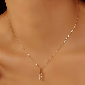 Close-up of a rose gold rectangle pendant with pavé diamonds on a delicate neck chain