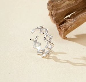 Detailed view of silver S925 geometric hollow open ring on a natural wooden display