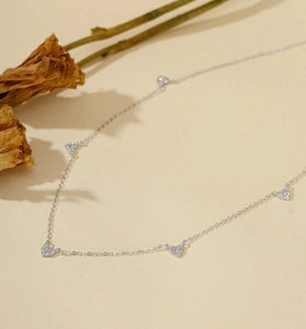 Détail macro du collier en argent S925 avec cinq pendentifs cœur et zircons blancs