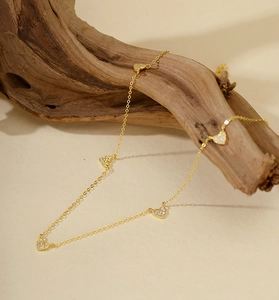 Gros plan sur le collier en argent S925 doré avec cinq cœurs brillants en zircon