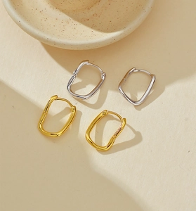 Close-up of gold and silver S925 sterling silver irregular geometric huggie earrings