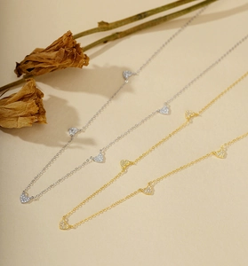 Gros plan de pendentifs cœur en zircon argent et or sur des chaînes délicates