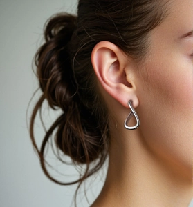 Close-up of S925 sterling silver geometric hoop earring worn by a female model