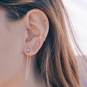 Gros plan de boucles d'oreilles dorées à franges avec zircon sur un mannequin