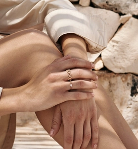 Close-up of gold layered rings featuring a zigzag open design and a marquise-cut crystal