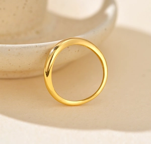 Nahaufnahme eines polierten S925 Sterlingsilberrings in Gold auf Keramiktablett