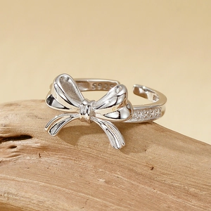 Bague nœud élégante en argent S925 avec zircons sur un présentoir en bois