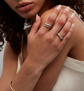 Nahaufnahme eines zweischichtigen Goldrings und eines diamantbesetzten Rings am Fingermodell