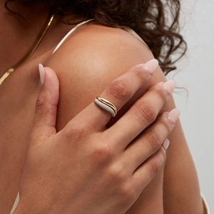 Eleganter goldener Wellenring mit Zirkonia-Besatz an der Hand eines weiblichen Models