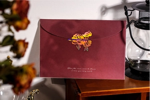 Détail d'une enveloppe bordeaux avec rose holographique et décor rétro vintage