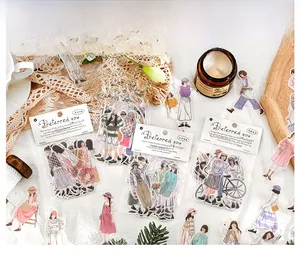 Détail d'autocollants de personnages de mode pour scrapbooking sur fond de dentelle blanche