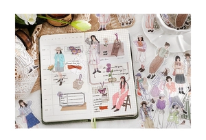 Détail d'autocollants de personnages à l'aquarelle sur une page de journal quadrillée