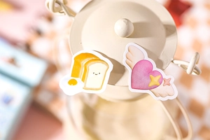 Gros plan d'autocollants mignons de toast et de cœur sur une lampe en métal crème