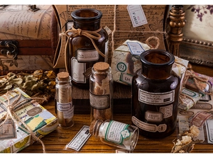 Close-up of vintage aesthetic stationery labels and glass bottles for scrapbooking