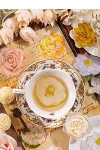 Macro shot of 3D floral stickers with holographic gold edges on vintage letter background