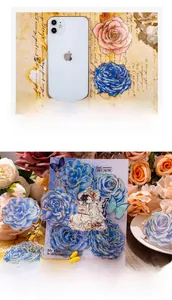 Detail of floral PET stickers with gold accents compared to phone for size scale