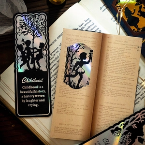 Holographic laser-cut silhouette bookmarks featuring childhood motifs on vintage books