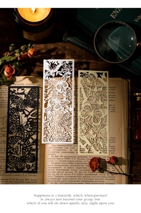 Macro detail of laser-cut butterfly bookmarks on vintage book with warm lighting