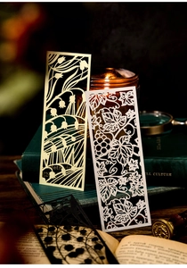 Detail of laser-cut lily of the valley and vine bookmarks on vintage book spine