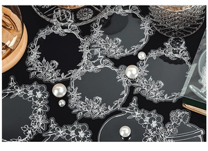 Macro detail of PET floral stickers with vintage vessel motifs on dark background