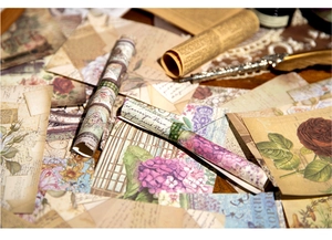 Close-up of vintage scrapbook paper featuring antique floral designs and calligraphy