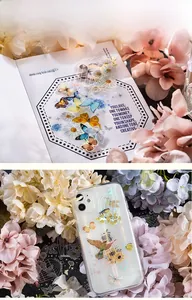 Macro detail of retro PET stickers with gold foil butterflies and cages on a phone case