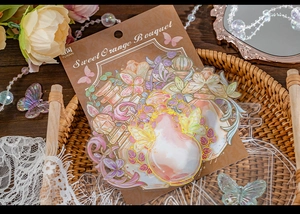 Detailed view of vintage gold foil butterfly and perfume bottle stickers for journaling