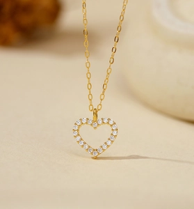 Close-up of heart pendant necklace in gold with sparkling white cubic zirconia pave