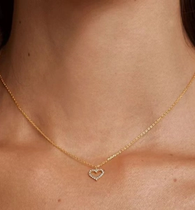 Close-up of a 925 silver golden necklace with a hollow heart pendant and pavé zircons