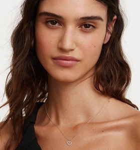 Detailed close-up of hollow heart pendant necklace with shimmering cubic zirconia inlay