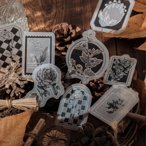 Zwart-witte botanische stickers met zilverfolie afwerking op een rustieke houten achtergrond