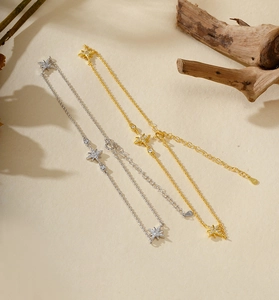 Détail de bracelets étoiles dorés et argentés avec zircon sur une surface beige