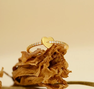 Macro detail of gold-plated S925 silver ring featuring heart design and pavé zircons