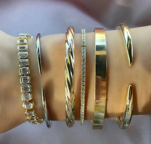 Detailed stack of gold and silver bangles featuring twist, pave, and flat styles