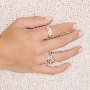 Detail of stacked S925 silver rings with star and heart patterns and crystal pavé