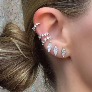 Close-up of geometric S925 silver stud earrings and paved diamond ear cuffs set