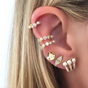 Macro view of geometric gold S925 sterling silver ear cuffs with pearls and diamonds